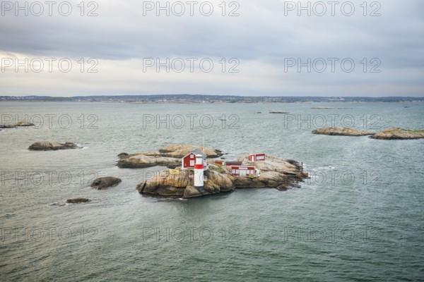 Small rocky island with lighthouse and red buildings in the calm sea, near Gothenburg, Västra Götalands län, Sweden