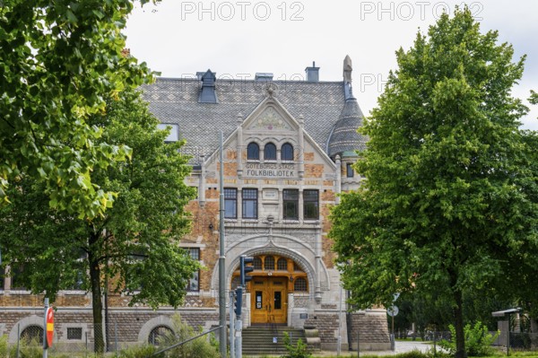 Folksbibliotek Historical Library in Götenborg with Gothic style, surrounded by trees with green leaves, Gothenburg, Västra Götalands län, Sweden
