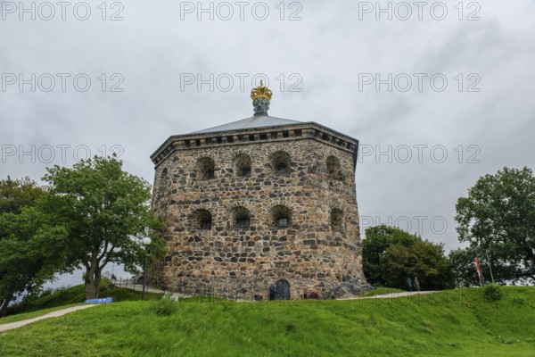 Massive historic stone fortress Skansen Kronan with a decorative crown on a hill surrounded by trees, Gothenburg's Skansen Kronan with historic signs, rustic masonry, Gothenburg, Västra Götalands län, Sweden