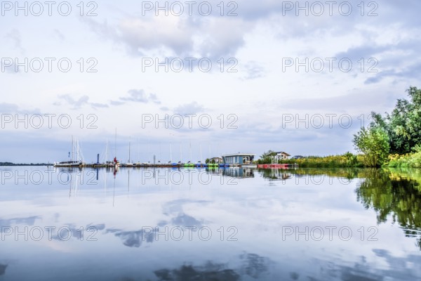 Tranquil Dümmer See with several boats in the harbor and clouds, Dümmerlohausen, Damme, Lower Saxony, Germany