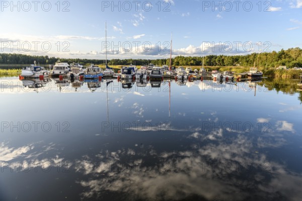 Several boats are moored in the quiet pleasure boat harbor of Ekenäs, water reflects the sky, Ekenäs, Värmlandsnäs peninsula, Värmlands län, Sweden