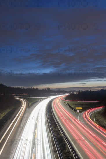 Night view of a motorway with red and white light trails against a cloudy sky, near Stuttgart, Baden-Württemberg, Germany
