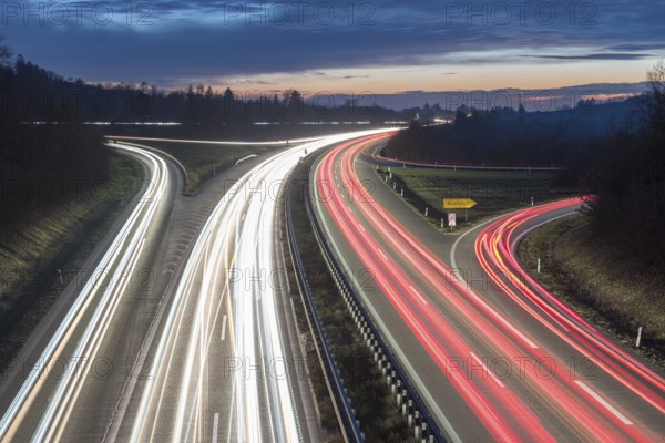 Evening long exposure of a motorway with light trails and cloudy sky in the background, near Stuttgart, Baden-Württemberg, Germany