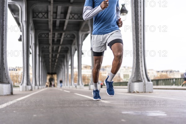 Young man running a daily urban workout across bir hakeim bridge in paris, showcasing fitness, determination and healthy city living against iconic architecture