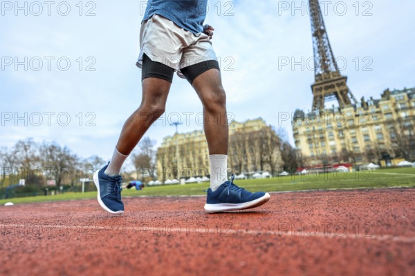 Athlete running on a red track with the iconic eiffel tower and parisian buildings in the background, combining urban landscape with fitness and active lifestyle