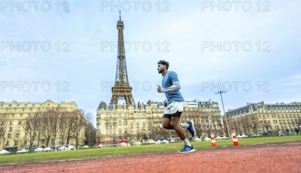 Male athlete intensely running on a red synthetic track, training and exercising with the iconic eiffel tower and classic parisian buildings creating an urban outdoor fitness backdrop
