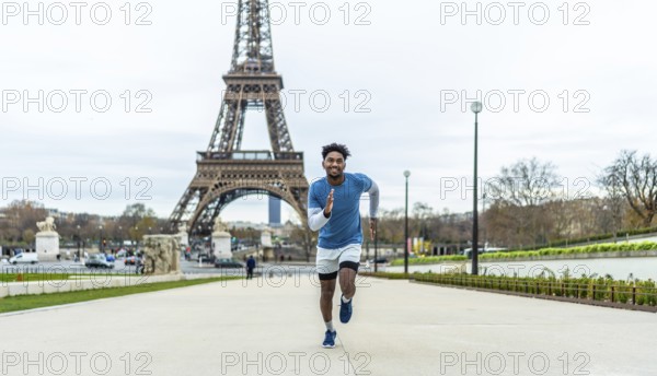 Young man actively running outdoors in front of the eiffel tower, symbolizing fitness, health, and urban sport against the iconic backdrop of the french capital