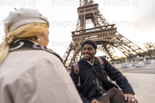 Diverse couple sharing a loving moment while travelling in paris, admiring the iconic eiffel tower in the background, representing romance, destination travel, and connection