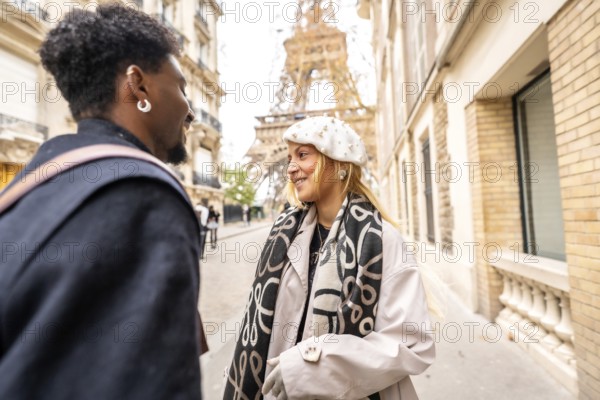 Happy diverse couple smiling and interacting on a parisian street with the eiffel tower in the background, symbolizing romance, travel, and urban exploration