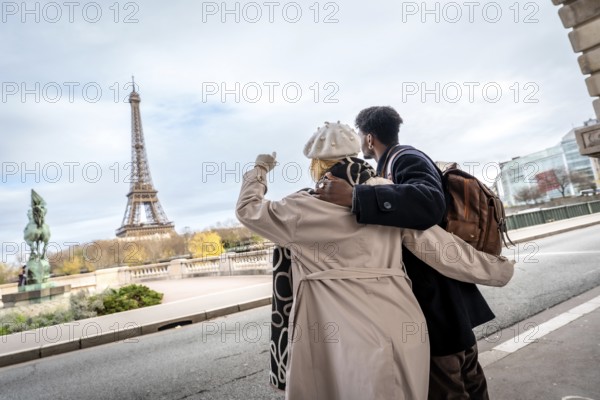 Tourists standing arm in arm along a parisian street, admiring the iconic eiffel tower in the distance, representing travel, romance, and an unforgettable european vacation
