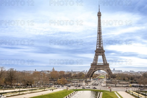 Eiffel tower rising above trocadero gardens, iconic paris skyline and historic monument framed by promenades, trees and a dynamic cloudy sky for travel and tourism use
