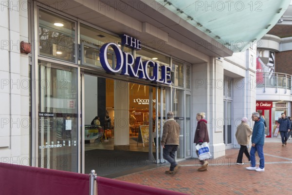 Shoppers walking into The Oracle shopping centre, town centre of Reading, Berkshire, England, UK