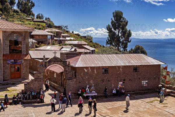 A picturesque village in the Andes with traditional buildings surrounded by mountains and clear skies, The city's large square on Taquile Island in Lake Titicaca in Peru