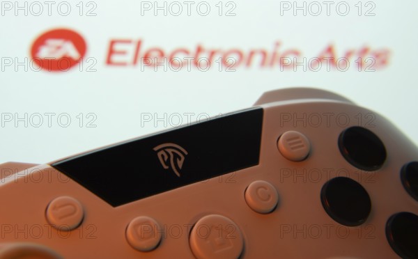 Dhaka, Bangladesh- 24 Mar 2025: A close-up of a gamepad with the Electronic Arts seen on screen in the background