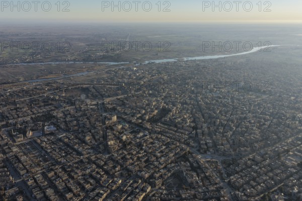 In Deir ez-Zor, Eastern Syria on January 21, 2026, an aerial drone shot captures the city landscape after Syrian Government forces successfully secured control. The deployment follows the withdrawal of SDF (Syrian Democratic Forces) elements as part of the broader strategic shifts and integration agreements in the region. The footage shows the city's infrastructure and the Euphrates River under the new military administration, Deir ez-Zor, Deir ez-Zor, Syria
