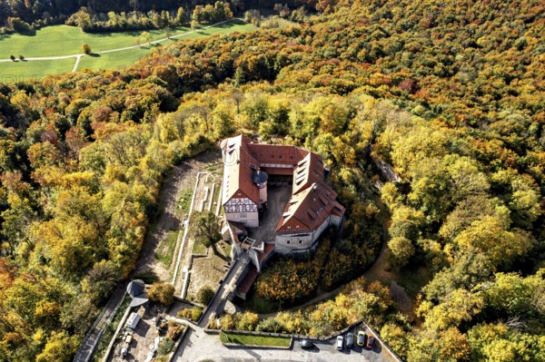 Castle nestled in colorful autumn landscape, surrounded by lush forest, seen from the air, Bodenstein Castle in the Eichsfeld district of Thuringia