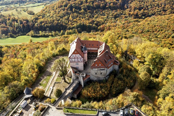 Historic castle surrounded by autumnal forest in a beautiful landscape taken from the air, Bodenstein Castle in the Eichsfeld district of Thuringia