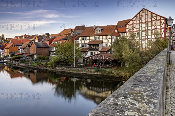 Half-timbered houses on a river with beer garden and bridge in an autumn atmosphere, The town of Bad Sooden Allendorf an der Werra in the Werra Meissner district of Hesse