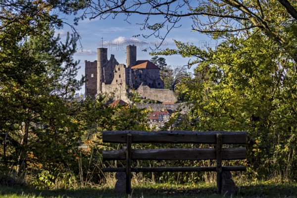 Bench in the foreground, medieval castle surrounded by trees, autumnal atmosphere, Hanstein Castle near Bornhagen in the Eichsfeld district of Thuringia