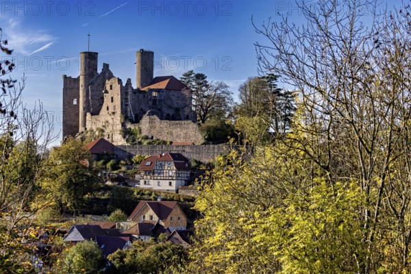 View of medieval castle above a village with autumn trees, Hanstein Castle near Bornhagen in the Eichsfeld district of Thuringia
