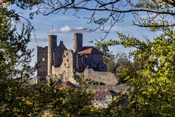 Medieval castle with stone towers, surrounded by trees under a blue sky, Hanstein Castle near Bornhagen in the Eichsfeld district of Thuringia