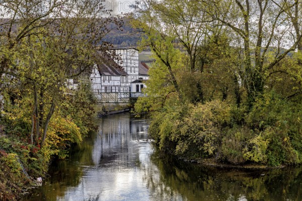 A picturesque village with half-timbered houses on a quiet river, surrounded by autumn trees, Wanfried an der Werra in the Werra Meissner district in Hesse