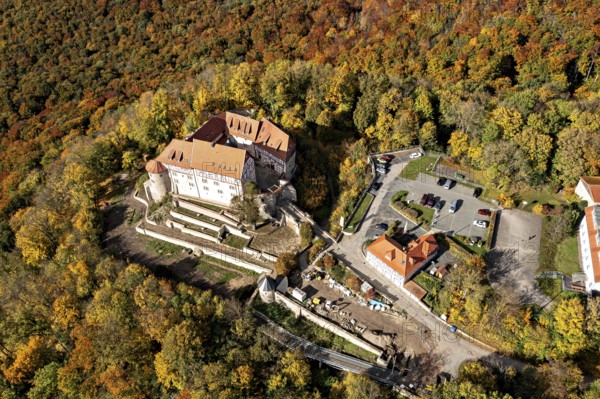 Castle complex surrounded by autumn forest, aerial view of the countryside, Bodenstein Castle in the Eichsfeld district of Thuringia