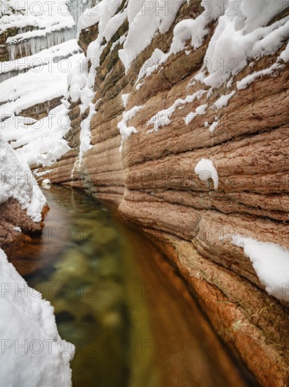 Taugl or Tauglbach flows through the snow-covered and icy red gorge, also Marmorklamm, Bad Vigaun, Tennengau, Salzburg, Austria
