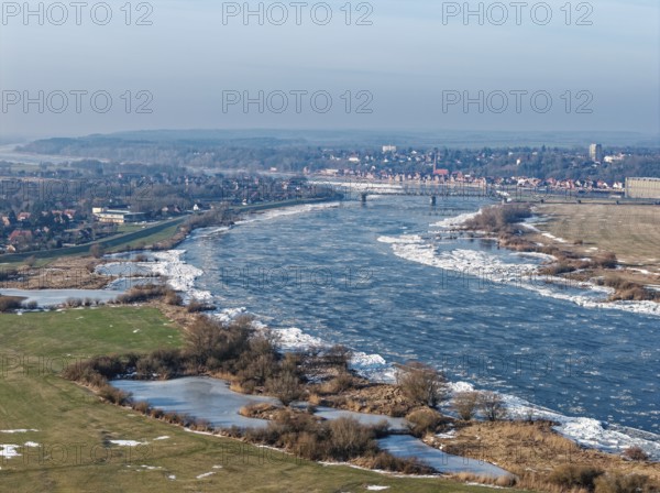 Icy riverbanks of the Elbe and ice in the foothills of the Elbe near Hohnstorf, Lüneburg district, on a cold winter day. In the background, the city of Lauenburg. aerial view. Hohnstorf, Lower Saxony, Germany