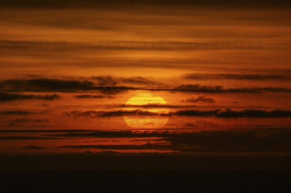 Sunset behind clouds, Baltic Sea