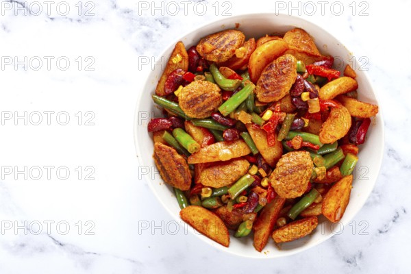 Steakhouse pfanne, fried potato slices, with meatballs, and vegetable mixture, on a white plate