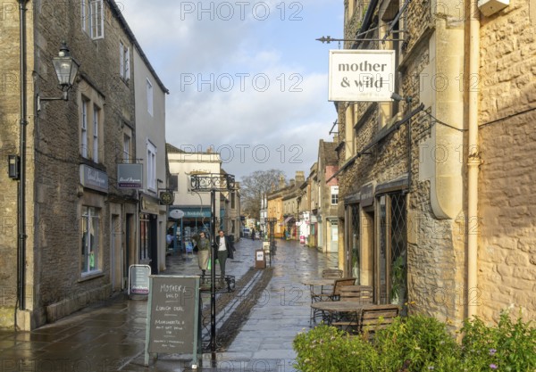 Wet pavements after rain in pedestrianised High Street are of town centre of Corsham Wiltshire, England, UK - quiet, few people
