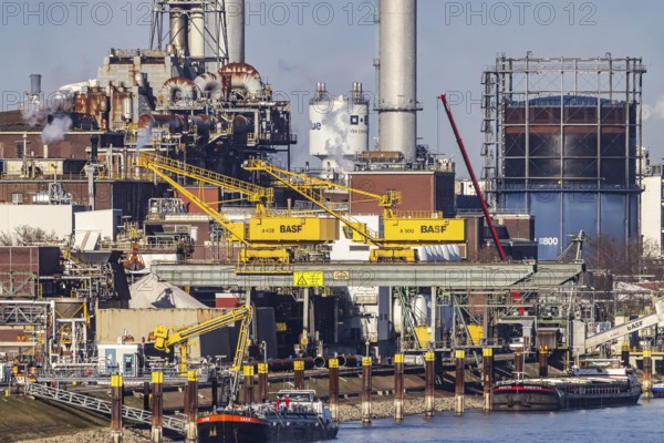 BASF factory site with chemical plants and chimneys. Baden aniline and soda factories. chemical plant. Port cranes unloading a cargo ship. Ludwigshafen am Rhein, Rhineland-Palatinate, Germany