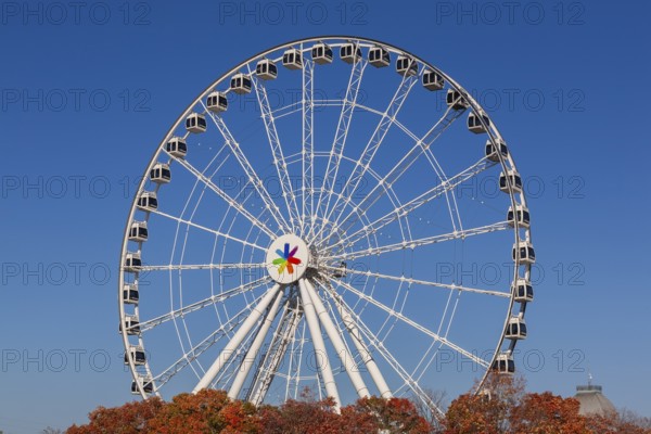 The Montreal Observation Ferris Wheel or La Grande Roue de Montreal amusement ride in autumn, Old Port of Montreal, Quebec, Canada. George Ferris (1859–96), is the American engineer who invented the ferris wheel