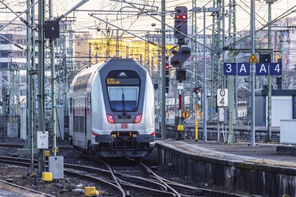 InterCity IC to Zurich leaving Stuttgart Central Station in the morning. Rail signals and overhead lines in early morning light. Stuttgart, Baden-Württemberg, Germany