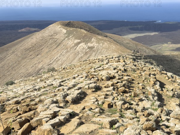 View from Caldera Blanca volcano against blue sky with white clouds, Mancha Blanca, Lanzarote, Canary Islands, Spain