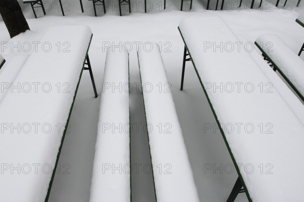 Winter in the English Garden, snow-covered beer garden tables and benches, Munich, Bavaria, Germany