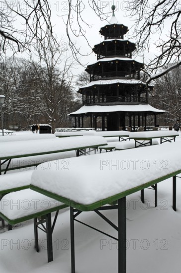 Winter in the English Garden, snow-covered beer garden tables and benches, Chinese Tower, Munich, Bavaria, Germany