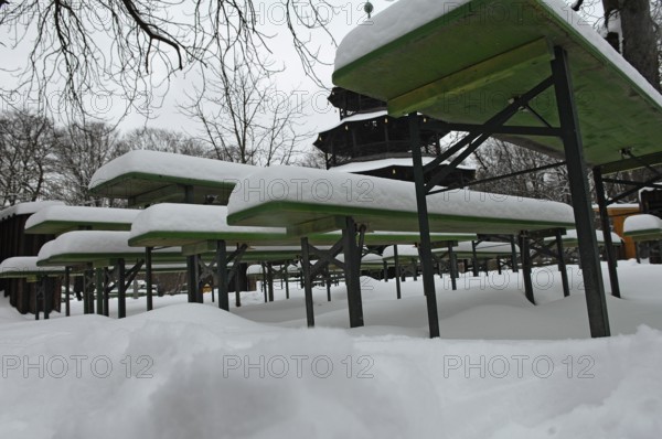Winter in the English Garden, snow-covered beer garden tables and benches, Chinese Tower, Munich, Bavaria, Germany