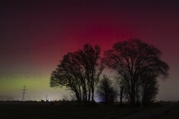 Northern lights (aurora borealis) glow red and green in the evening sky over Germany, Frankfurt am Main, Hesse, Germany