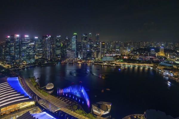 Aerial view from Marina Bay Sands SkyPark Observation Deck over the illuminated skyline of the city Singapore at night, Southeast Asia