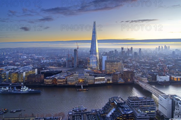 The Shard, pyramid-shaped skyscraper and London Bridge Station along the River Thames in Southwark at sunset at the capital city London, England, UK
