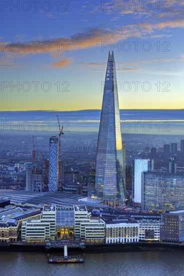 The Shard, pyramid-shaped skyscraper and London Bridge Station along the River Thames in Southwark at sunset at the capital city London, England, UK