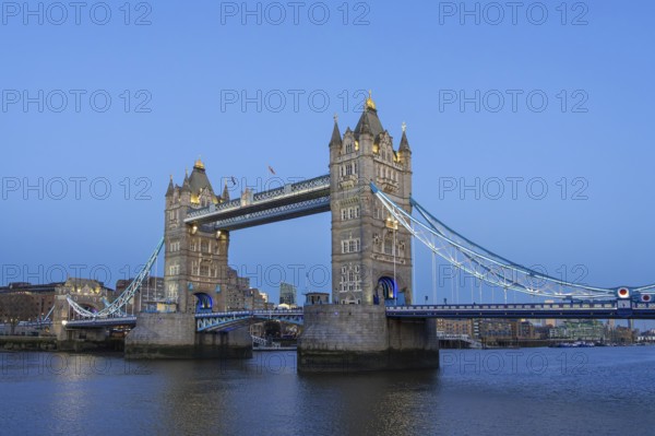 19th century Tower Bridge, neo-Gothic bascule / suspension bridge crossing the River Thames in the capital city London at dusk, England, UK
