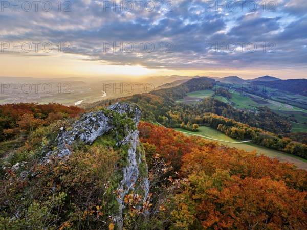 View from the Gisliflue of an autumn-colored forest, behind the Jurassic foothills with water fluh and stripes in the light of the setting sun, Talheim, Canton, Aargau, Switzerland