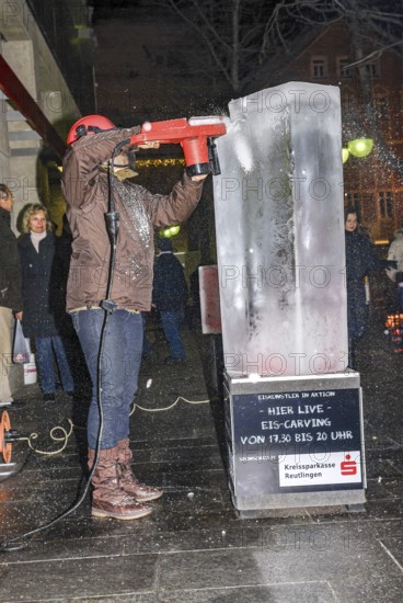 An ice sculpture is being created: ice carving street action as part of the long shopping night in the city center of Reutlingen, Baden-Württemberg, Germany, for editorial use only