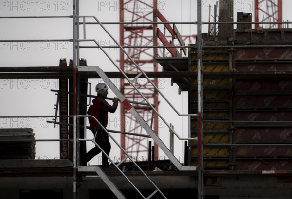 Construction site, scaffolding work on a large construction project, apartments and commercial premises, symbolic image of the construction industry