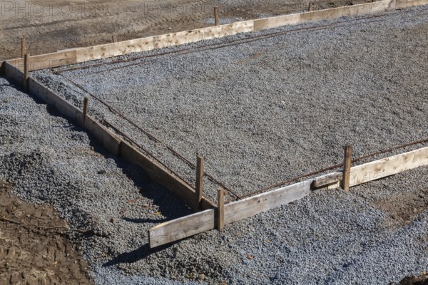 Wooden concrete pouring forms and bed of crushed and compacted stone aggregate to rest concrete slab floor of a building on at construction site, Quebec, Canada