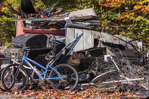 Pile of discarded metal objects including bicycles, sheet metal cladding, pipes, steel wire waiting for transport to recycling yard, Quebec, Canada