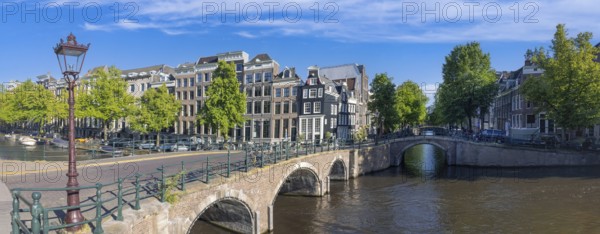 Holland, Amsterdam canals with boats, scenic bridges and historic city center, UNESCO World Heritage site